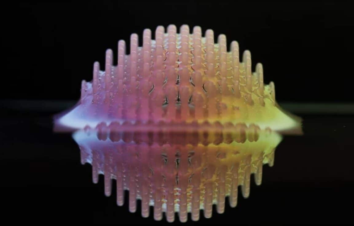 Surface de l’eau façonnée en reliefs réguliers grâce à une structure imprimée en 3D, illustrant les effets de la tension de surface.